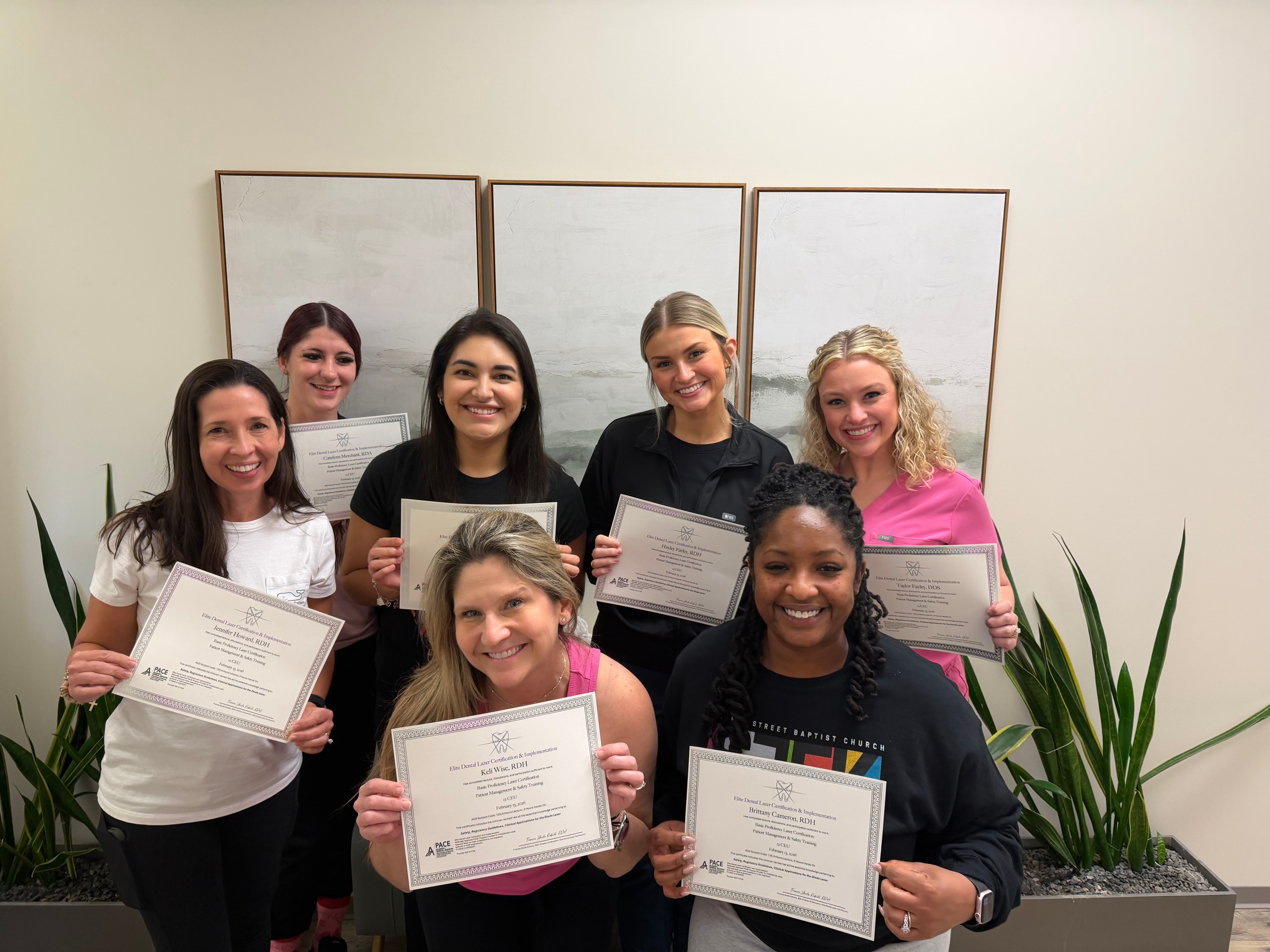 Smiling dental practice team after completing group laser certification